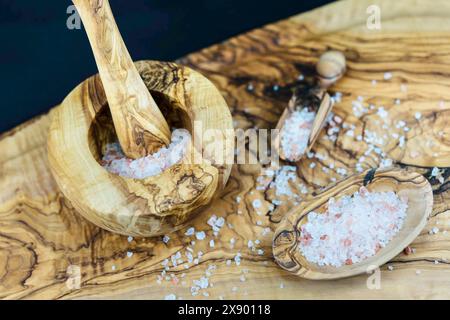 Himalaya-Salz in einer Holzschale, Holzschaufel und Mörtel Stockfoto