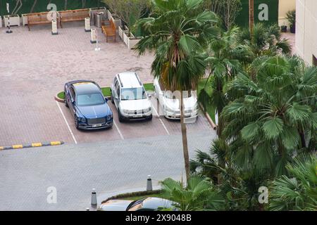 Blick aus der Höhe auf Autos auf dem Parkplatz in Dubai City. Stockfoto