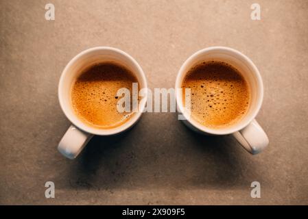 Zwei weiße Tassen mit Espresso auf Holztisch. Hochwertige Fotos Stockfoto