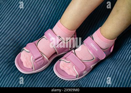 Lemberg, Ukraine - 24. Mai 2024: Pinkfarbene Geox Vaniett Sandalen auf Kinderfüßen Stockfoto