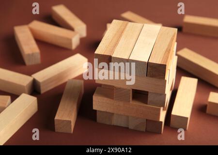 Holzblöcke auf braunem Hintergrund, Strategiespiel als Businessplan für Teamarbeit. Draufsicht Stockfoto
