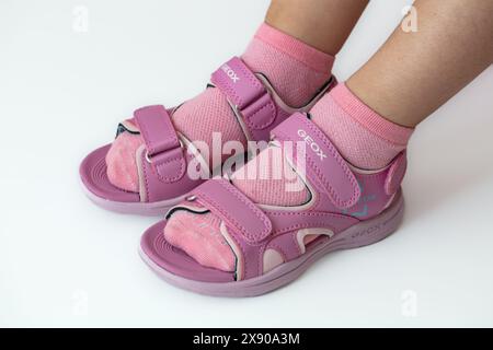 Lemberg, Ukraine - 24. Mai 2024: Pinkfarbene Geox Vaniett Sandalen auf Kinderfüßen Stockfoto