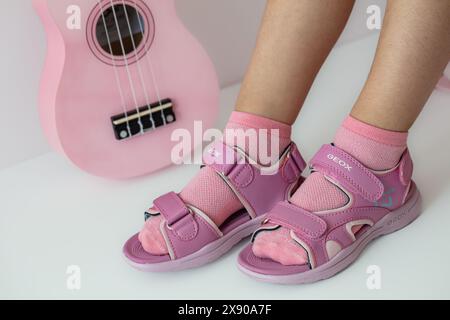 Lemberg, Ukraine - 24. Mai 2024: Pinkfarbene Geox Vaniett Sandalen auf Kinderfüßen Stockfoto