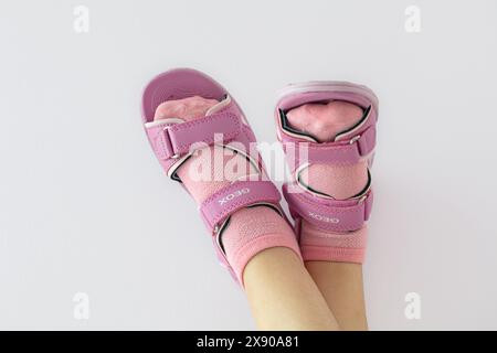 Lemberg, Ukraine - 24. Mai 2024: Pinkfarbene Geox Vaniett Sandalen auf Kinderfüßen Stockfoto