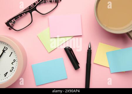 Foto oben von Haftnotizen, einer Tasse Kaffee und Gläsern auf rosafarbenem Hintergrund. Draufsicht Stockfoto