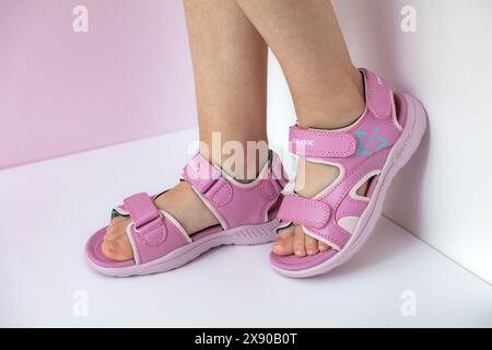 Lemberg, Ukraine - 24. Mai 2024: Pinkfarbene Geox Vaniett Sandalen auf Kinderfüßen Stockfoto