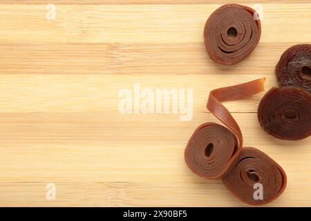 Fruchtpastille auf hölzernem Hintergrund. Fruchtrollen aus Himbeere, Äpfeln und Johannisbeere. Draufsicht Stockfoto