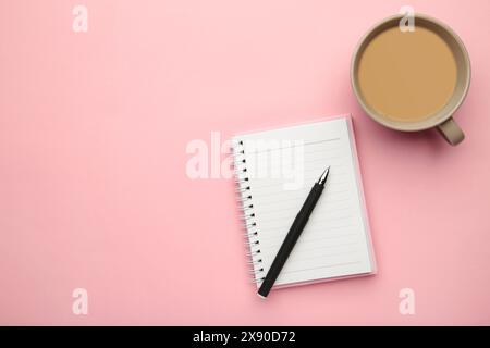 Aufgabenliste in einem Notizbuch geschrieben. Notizbuch mit einer To-do-Liste auf rosa mit einer Tasse Kaffee. Draufsicht Stockfoto