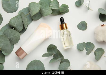 Organische Hautpflegeprodukte auf weißem Hintergrund mit frischen grünen Eukalyptusblättern. Draufsicht Stockfoto