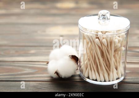 Baumwollknospen im Behälter mit Baumwollblume auf hölzernem braunen Hintergrund. Draufsicht Stockfoto