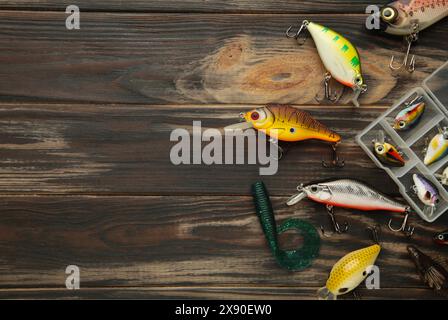 Nikolaev, Ukraine - 08. juli 2022: Bunte Angelköder, Wobbler, Spinner, auf braunem Holzschreibtisch verschiedene Angelköder von oben. Stockfoto