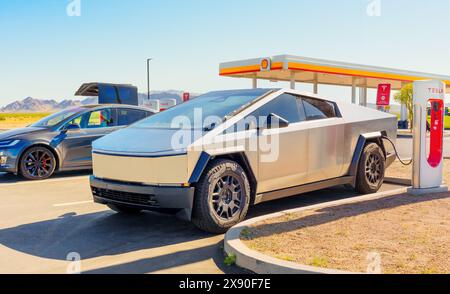 White Hills, Arizona – 14. April 2024: Cybertruck und Tesla Model X Elektroauto werden an eine Kompressorstation angeschlossen Stockfoto