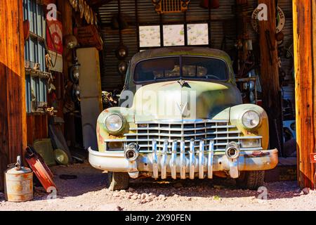 Nelson, Nevada - 15. April 2024: Verwitterter Oldtimer parkte in einer alten Garage an der alten Tankstelle der verlassenen Goldminensiedlung Stockfoto