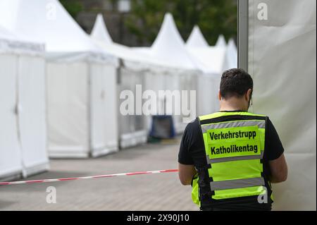 Erfurt, Deutschland. Mai 2024. Ein Mitglied des katholischen Tages-Verkehrsteams repariert eine Barriere. Die Aufbauarbeiten für den Katholikentag in der Erfurter Innenstadt sind in vollem Gange. Quelle: Heiko Rebsch/dpa/Alamy Live News Stockfoto