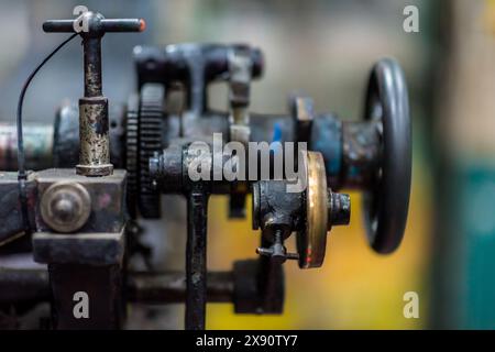 Detailansicht der mechanischen Übersetzung und des Handrads der historischen Buchdruckmaschine in einer Druckerei in Cali, Kolumbien. Stockfoto