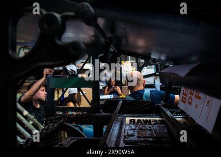 Drucker, Künstler und Studenten des Grafikdesigns diskutieren den Druckprozess in einer Druckwerkstatt in Cali, Kolumbien. Stockfoto