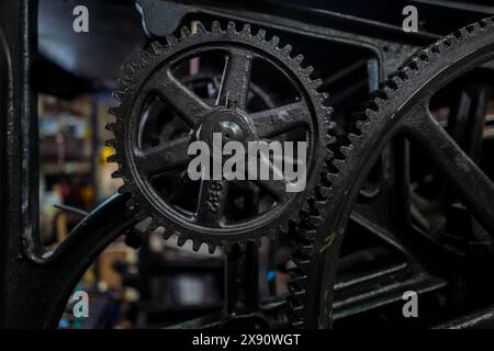 Detailansicht des Getriebes der historischen Buchdruckmaschine in einer Druckwerkstatt in Cali, Kolumbien, am 5. März 2024. Stockfoto