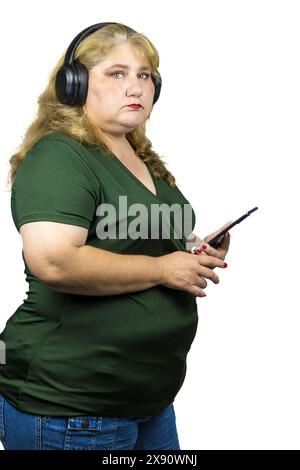 Weiße weiße Frau, die mit Bluetooth-Kopfhörern über ihr Smartphone in die digitale Welt eingetaucht ist. Stockfoto