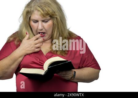 Das Bild fängt eine 50-jährige Weiße mit blonden Haaren ein, tief vertieft in ein Buch. Stockfoto