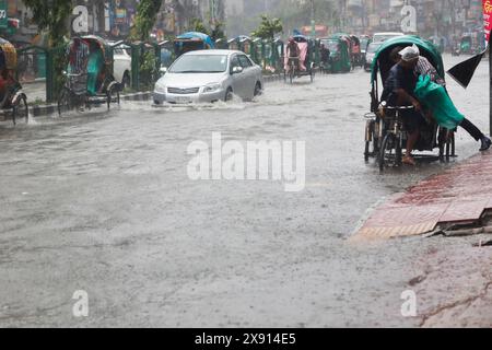 Dhaka, Bangladesch - 27. Mai 2024: Fahrzeuge versuchen, durch eine überflutete Straße zu fahren; starker Regen durch Zyklon Remal verursachte Wasserabfall in verschiedenen R Stockfoto