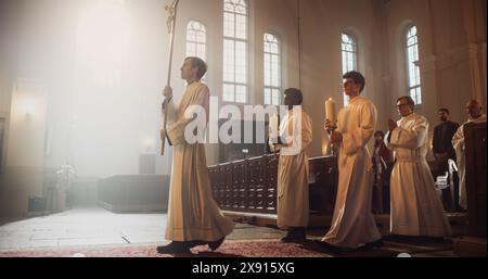 Liturgie in der Großen Kirche: Majestätische Prozession von Ministern und Priestern, die mit dem Prozessionskreuz gehen. Die Gemeinde steht in Ehrfurcht, die Christen freuen sich über die Zeremonie der Messe Stockfoto