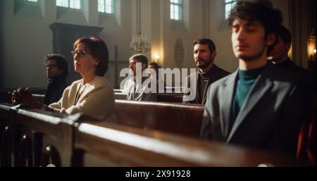 Gruppe treuer Pfarrer in der Großen alten Kirche, die Predigt hören. Christliche Gemeinde, die Trost im Glauben und religiösen Glauben sucht. Frommer sitzen, beten, von Gott leiten lassen Stockfoto