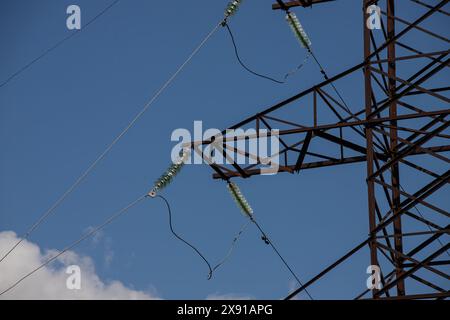 Stromleitungen im Hintergrund von Nahaufnahmen mit blauem Himmel. Elektrische Nabe an der Stange. Elektrizitätsanlage mit Kopierraum. Hochspannungsleitungen am Himmel. Stockfoto