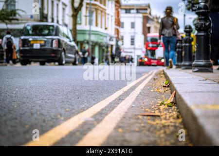 LONDON - Niedriger Nahfokus auf die geschäftige Einkaufsstraße mit anonymen Leuten und Geschäften Stockfoto