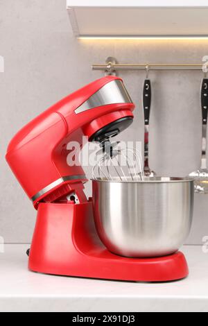 Moderner roter Standmixer auf weißem Tisch in der Küche Stockfoto
