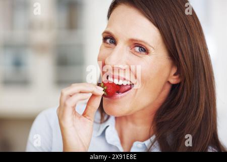 Frau, Porträt und Erdbeere für Vitamine zu Hause, Ernährung und vegane Ernährung für gesunde Entgiftung. Weibliche Person, Obst und Mineralien zum Frühstück Stockfoto