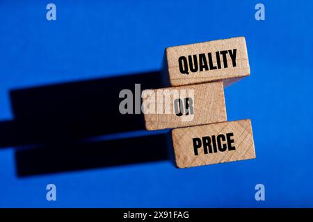 Qualitäts- oder Preiswörter auf Holzblöcken mit blauem Hintergrund. Konzeptionelles Qualitäts- oder Preissymbol. Kopierbereich. Stockfoto