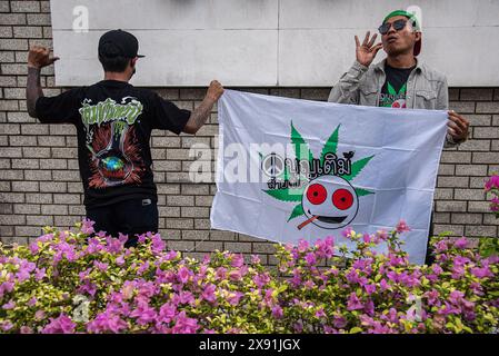 Bangkok, Thailand. Mai 2024. Cannabisaktivisten halten ein Banner und posieren für ein Foto während des Protestes. Eine Gruppe von Cannabisaktivisten und -Unterstützern versammelte sich vor dem Gebäude der Vereinten Nationen in Bangkok, um gegen die Möglichkeit der Wiederkriminalisierung von Cannabis zu protestieren, nachdem Cannabis in Thailand 2022 entkriminalisiert wurde. Die thailändische Regierung plant, sie bis Ende 2024 erneut unter Strafe zu stellen. (Foto: Peerapon Boonyakiat/SOPA Images/SIPA USA) Credit: SIPA USA/Alamy Live News Stockfoto