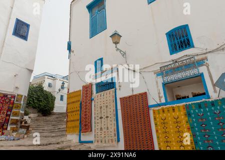 Mai 2024. Sidi Bou Said, Tunesien. Teppiche für Touristen-Souvenirs hängen vor einem Laden in den engen Gassen von Sidi Bou Said, einem hübschen Dorf in der Nähe von Th Stockfoto