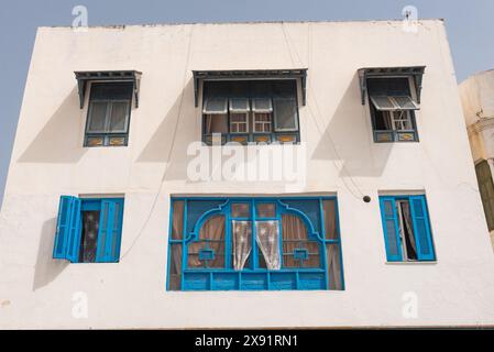 Klassische weiß getünchte Wände und blau lackierte Fenster tunesischer Architektur im UNESCO-Weltkulturerbe Tunis Medina am Mittelmeer Stockfoto