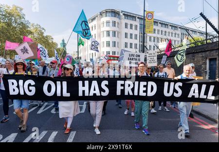 September 2023. Westminster, London, Großbritannien. März, um fossile Brennstoffe zu beenden. Demonstranten mit einem Banner, auf dem steht: „Das große Öl hat uns alle gebraten“. Stockfoto