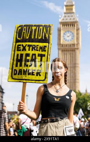 September 2023. Parliament Square, Westminster, London, Großbritannien. März, um fossile Brennstoffe zu beenden. Protestor mit Plakat mit der Aufschrift „Vorsicht Extreme Hitzegefahr“ Stockfoto