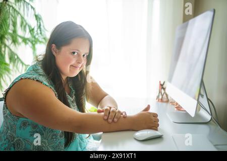 Porträt der Trisomie 21 Erwachsene arbeiten am Computer Stockfoto