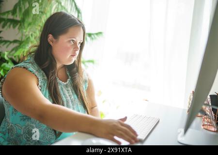 Porträt der Trisomie 21 Erwachsene arbeiten am Computer Stockfoto