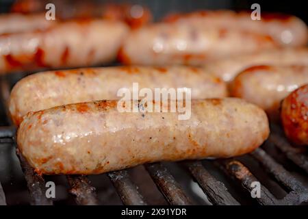 Nahaufnahme von Bratwürsten auf einem Gasgrill während eines Picknicks. Stockfoto