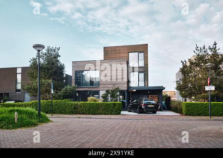 Niederlande, Amsterdam - 10. April 2024: Moderne Architektur eines Hauses mit Holzfassade Inligusterhof, Bezirk Ijburg Stockfoto