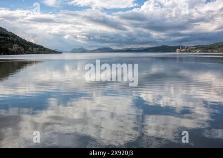 Wolken spiegeln sich wunderschön auf dem ruhigen Wasser von Embalse de Puente Nuevo in Espiel, Cordoba, und schaffen eine ruhige Landschaft. Stockfoto