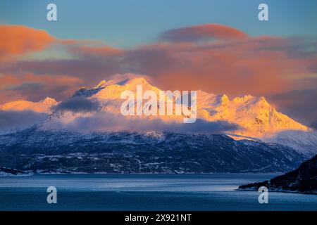Das magische Licht des ausgehenden Polartages auf den verschneiten Hügeln der Lofoten im Norden Norwegens Stockfoto