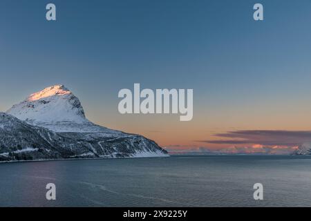 Das magische Licht des ausgehenden Polartages auf den verschneiten Hügeln der Lofoten im Norden Norwegens Stockfoto