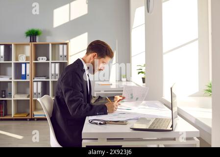 Architekt arbeitet im Büro, verwendet Stadtpläne und entwickelt einen neuen Bauplan Stockfoto