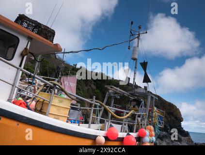 Cadgwith Cove Fischerboot mit der Flagge von St. Pirans, die auf den Klippen über der Bucht fliegt Stockfoto