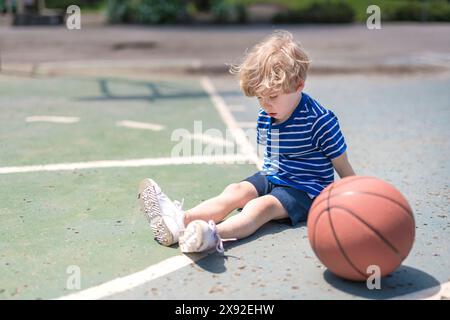 Sportverletzung. Junge mit Knietrauma nach Basketballspiel Stockfoto