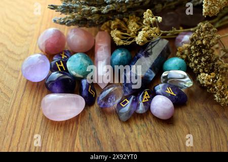 Skandinavische Runen aus Amethysten, Halbedelsteinkristallen und trockenen Kräutern. Vorhersagen, Hexerei, spirituelle esoterische Praxis. Stockfoto