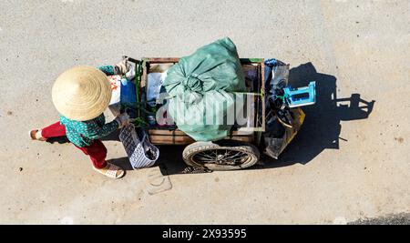 Vietnamesische Frau schiebt einen Wagen voller recycelbarer Abfälle, Saigon City, Vietnam. Stockfoto