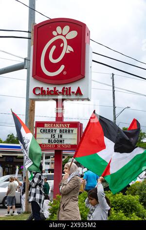 Toledo, Ohio, USA. Mai 2024. Pro-palästinensische Demonstranten schwenken palästinensische Flaggen, während sie während einer Toledo-Demonstration an einem Chick-Fil-A-Schild vorbeimarschieren. Das Kapitel der amerikanischen Muslime für Palästina Toledo organisierte den Protest als „Notfallprotest“ als Reaktion auf die israelischen Luftangriffe, die Vertriebene in Zelten in der Stadt Rafah im Süden des Gazastreifens getroffen haben. (Credit Image: © Stephen Zenner/SOPA Images via ZUMA Press Wire) NUR REDAKTIONELLE VERWENDUNG! Nicht für kommerzielle ZWECKE! Stockfoto