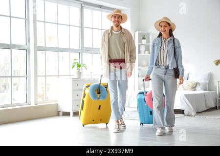 Junge Touristen mit Koffern, die im Hotelzimmer einchecken Stockfoto